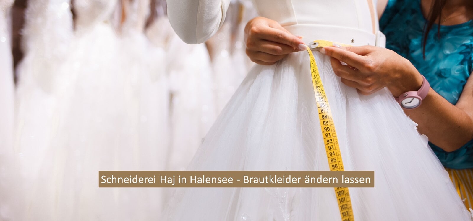 ein Brautkleid wird von einer Schneiderin vermessen